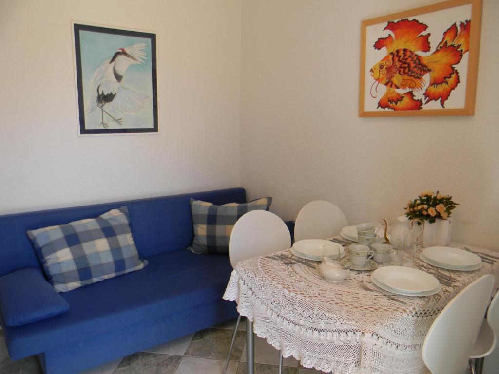 salon z niebieską kanapą i stołem w obiekcie Apartments Gabriel w Nin