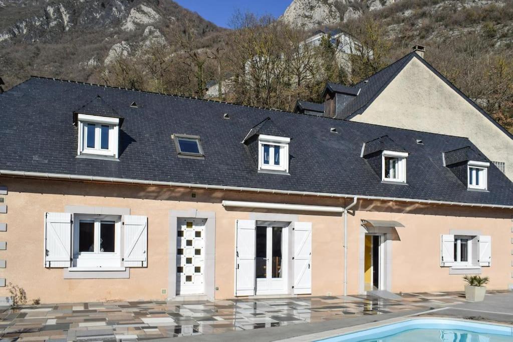 une maison avec un toit noir et une piscine dans l'établissement Villa Bellevue avec piscine, à Agos-Vidalos