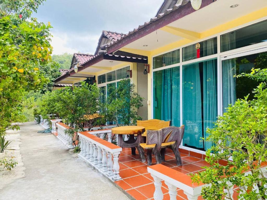 an outdoor patio with a wooden table and chairs at Sok San Villa Koh Rong in Phumĭ Kaôh Rŏng