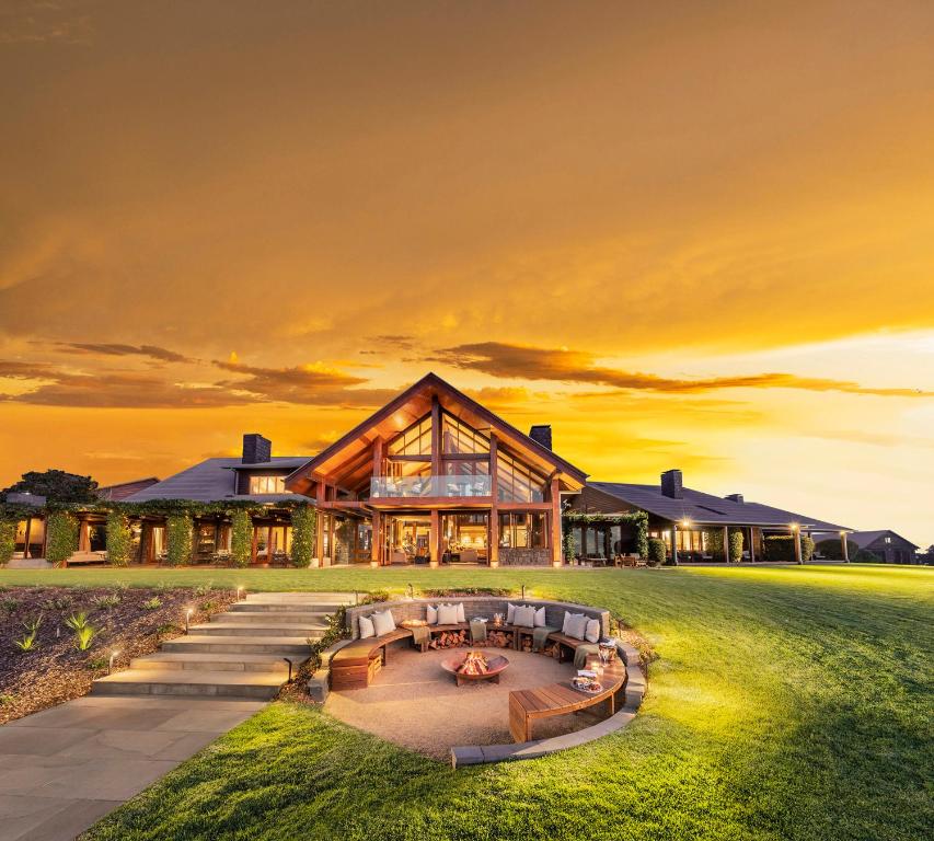 een huis op het strand met een zonsondergang op de achtergrond bij Spicers Peak Lodge in Maryvale