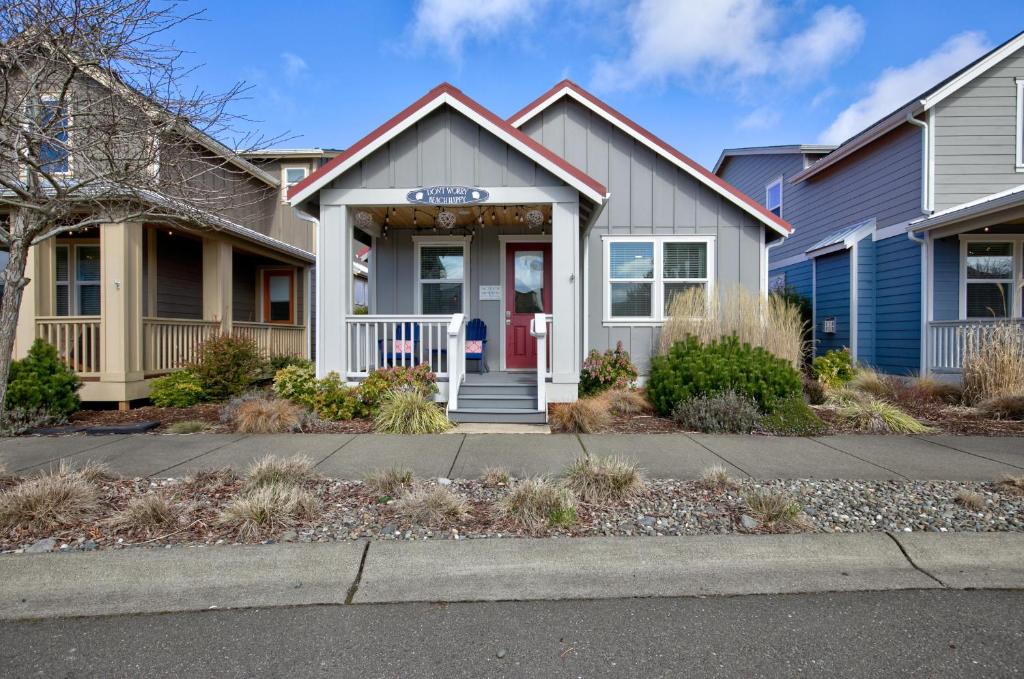 een huis met een rode deur in een straat bij Diggin It At The Beach Cottage Oyhut Bay Seaside Village in Ocean Shores