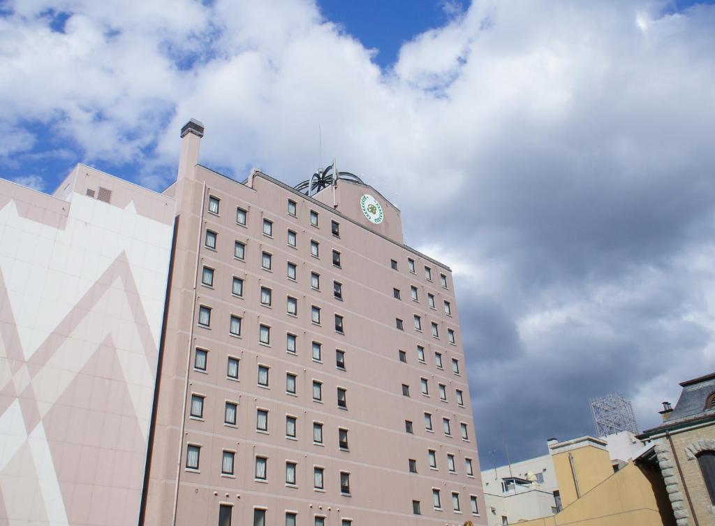 a tall building with a clock on the top of it at HOTEL BRIGHT INN MORIOKA in Morioka