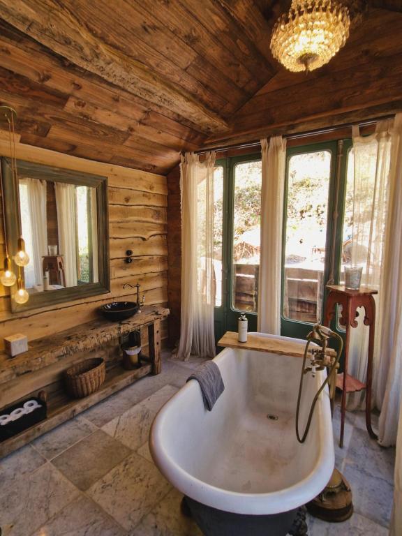 un ampio bagno con vasca in una casa di legno di Rêve Aveyron a Broquiès