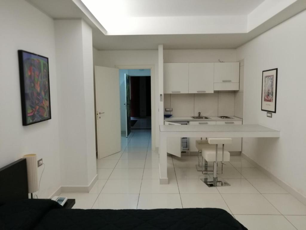 a white kitchen with a table and a counter at Hotel Residence Germaneto in Catanzaro