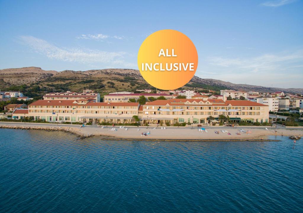 eine Luftansicht auf einen Strand mit einem großen Gebäude in der Unterkunft Family Hotel Pagus - All Inclusive in Pag