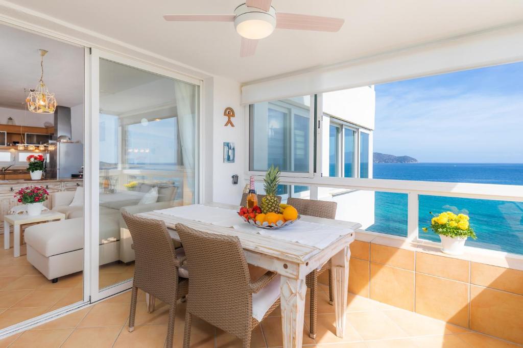 ein Esszimmer mit einem Tisch und Meerblick in der Unterkunft Strandwohnung Marina Park Playa in Cala Millor