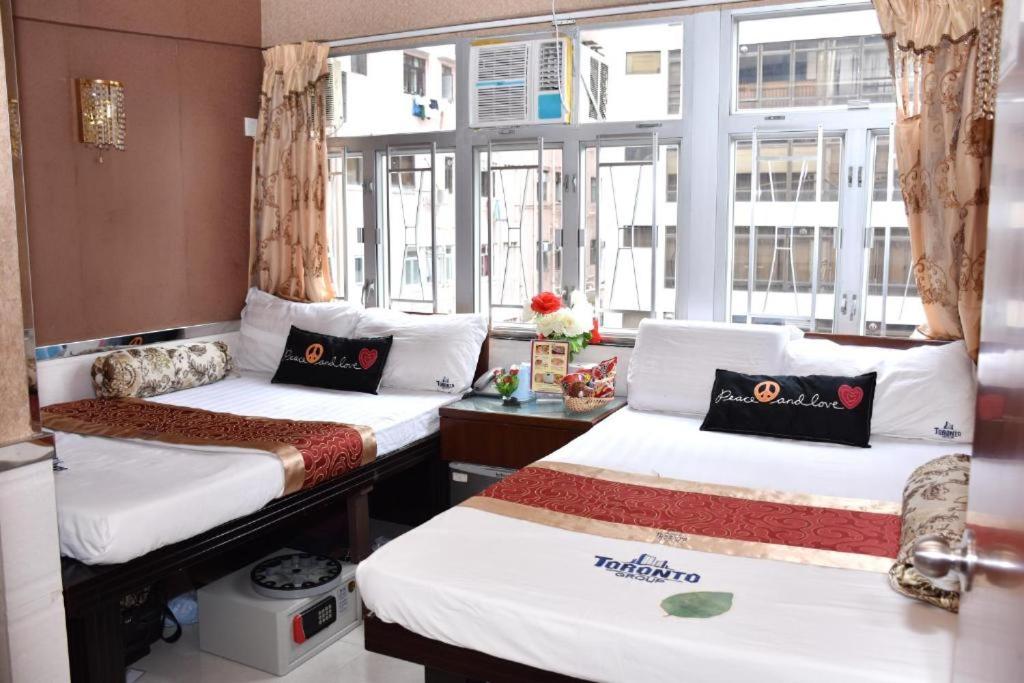 um quarto com duas camas e uma janela em Toronto Motel HongKong em Hong Kong