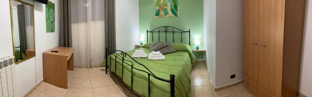 a bedroom with a green bed in a room at Confort home in Rende