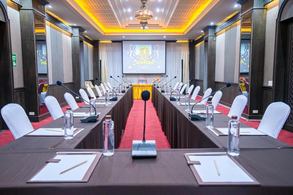 a conference room with long tables and white chairs at Amman Unique Hotel in Udon Thani