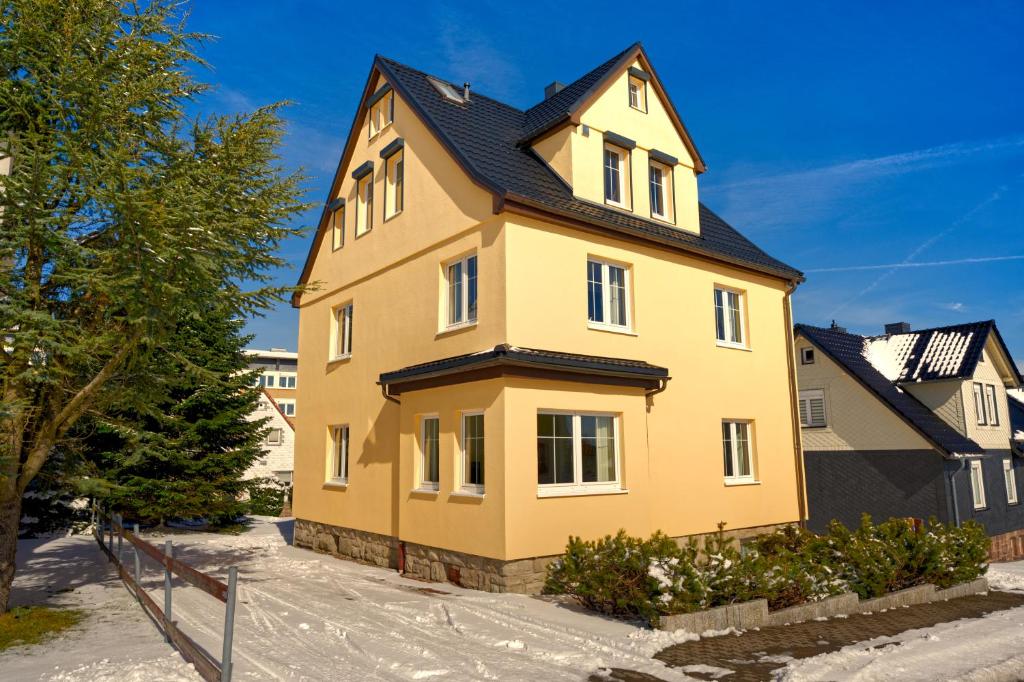 a yellow house with a black roof at Haus Susanne in Oberhof