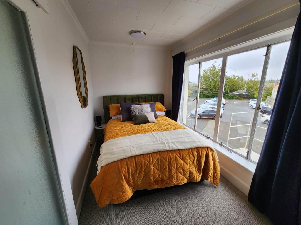 a bedroom with a bed and a large window at Art Deco Beauty on The Bay Hill in Timaru