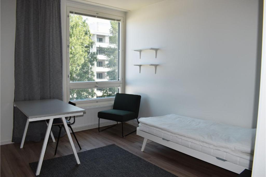 a room with a bed and a desk and a window at Soihtu Stay in Jyväskylä