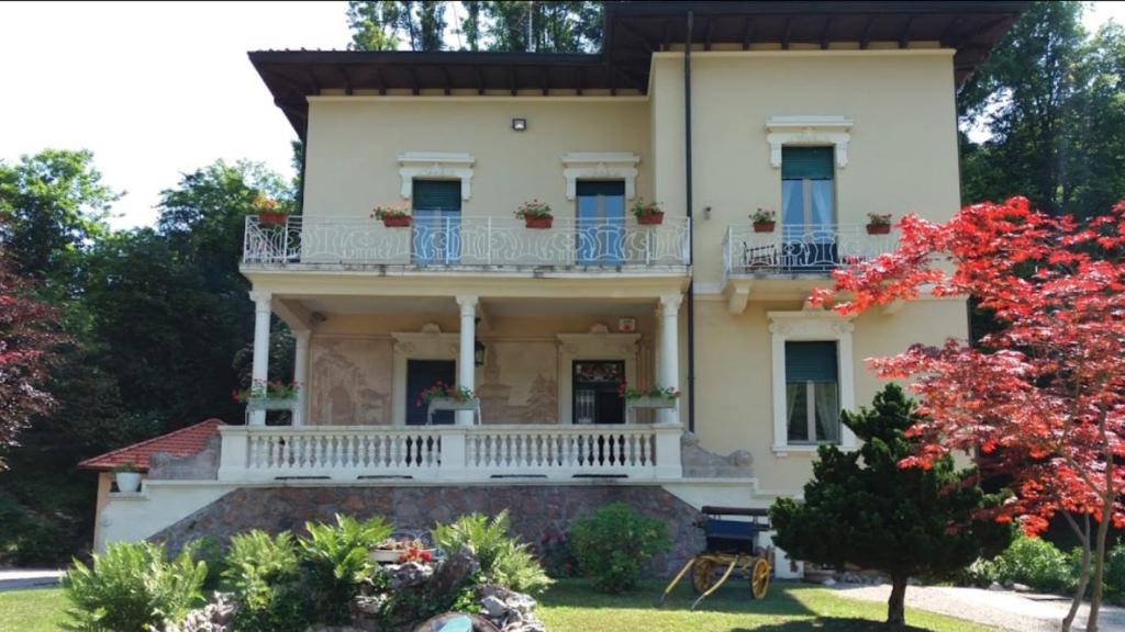 una grande casa con balcone e alberi di La Villa del Lago a Ghirla