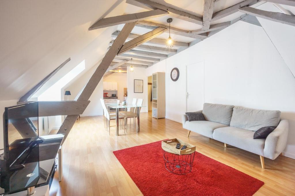 - un salon avec un canapé et un tapis rouge dans l'établissement Appartement dans le vieux Châteauroux, à Châteauroux