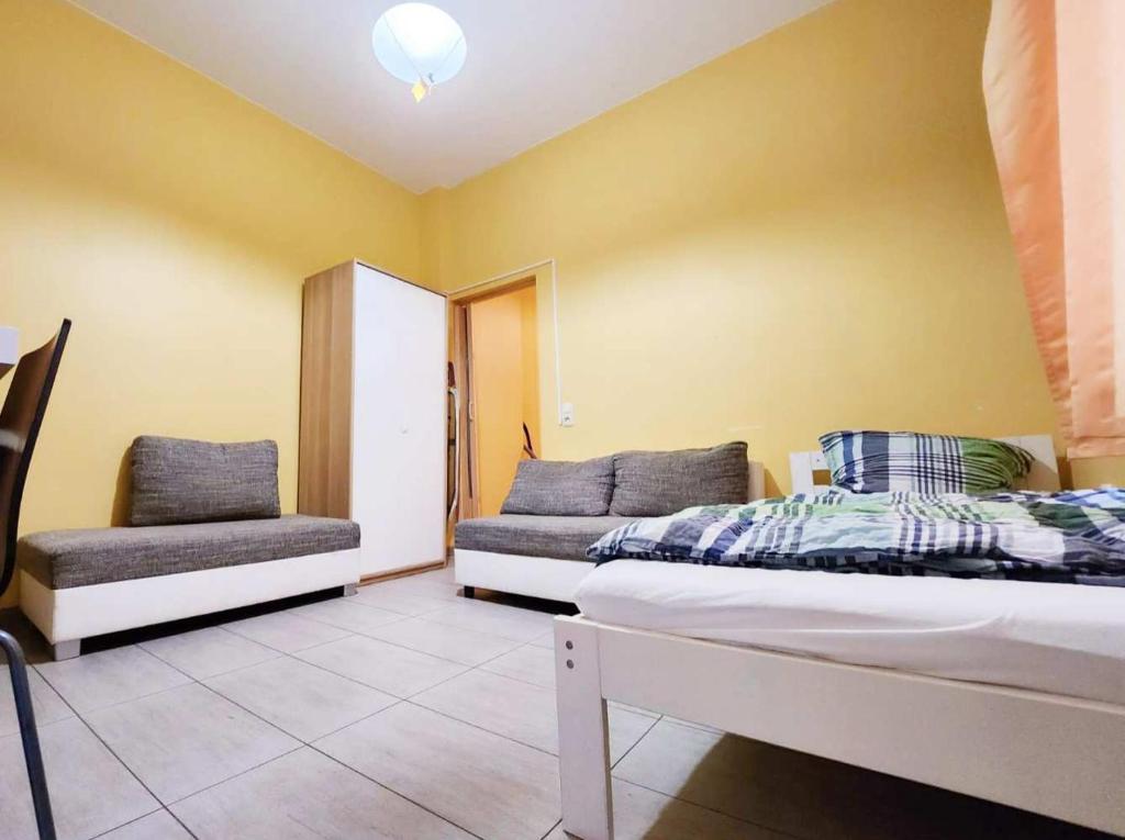 ein Schlafzimmer mit einem Bett und einem Stuhl in der Unterkunft Central located Apartments in Bergisch Gladbach