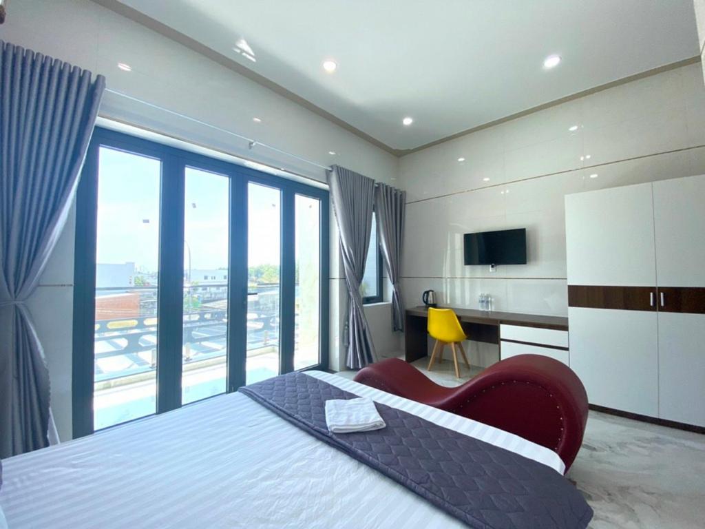 ビンチャウにあるMotel Hòa Hiệpのベッドと大きな窓が備わるホテルルームです。