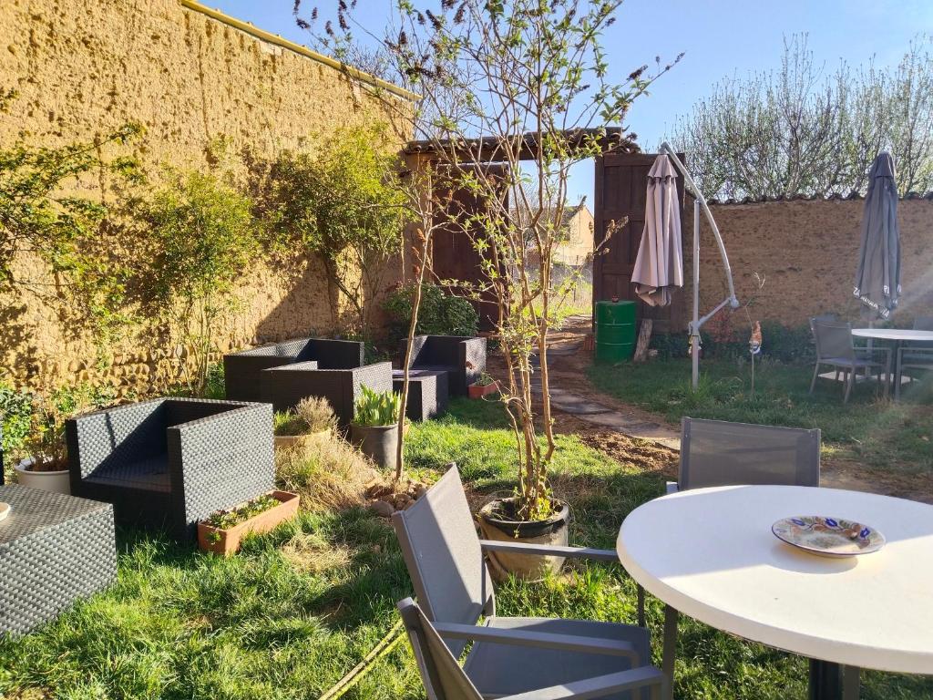 a patio with tables and chairs and an umbrella at Las Hadas Albergue Peregrinos - Atención personalizada in Reliegos