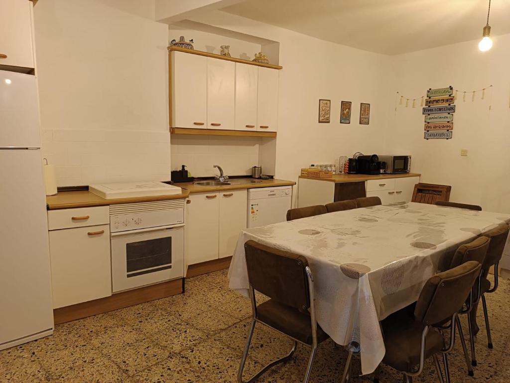 a kitchen with a table and chairs in a kitchen at Casa de pueblo cerca de Gredos y Navaluenga in Navalmoral