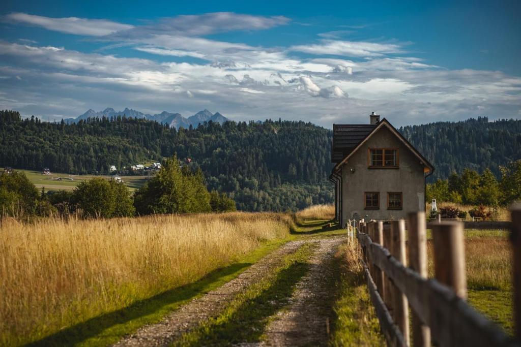 an old house in a field next to a fence at Ciche Pole in Maniowy