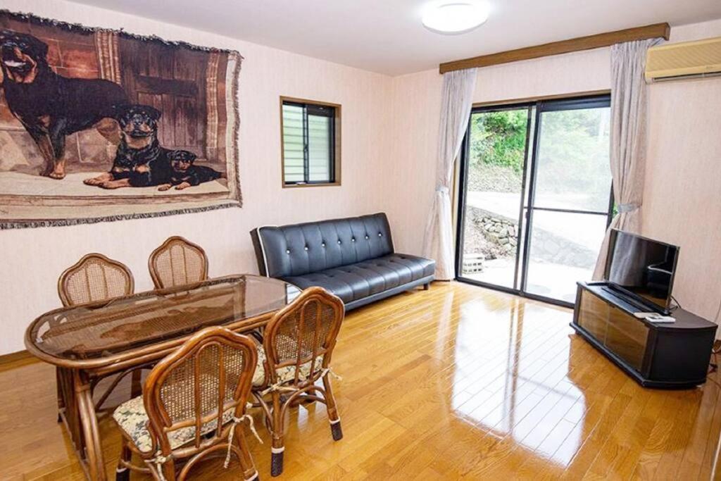 a living room with a table and a couch at Guest House Kiyohime in Tanabe