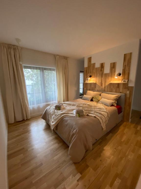 una camera da letto con un letto grande con pavimento in legno di Nook. The Design Apartment a Târgu-Mureş