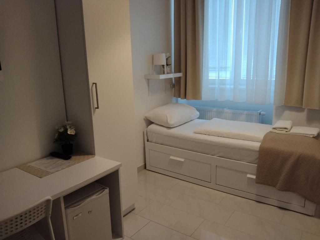 ウィーンにあるCH-Hotel Luka Budgetのベッドと窓が備わる小さな客室です。