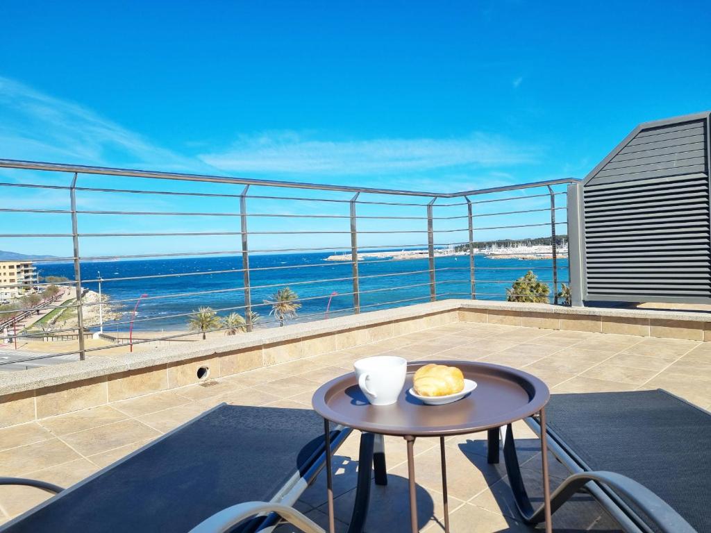 a table on a balcony with a view of the ocean at Apartamento Medusa in L'Escala