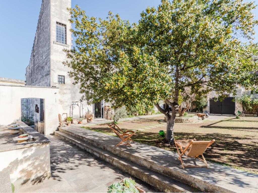 two chairs under a tree next to a building at Salento 4 Stars - Blue & Yellow in Squinzano