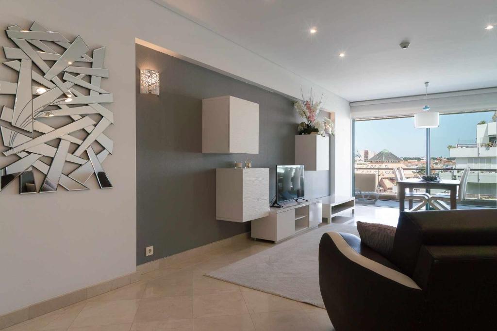 a living room with a couch and a television at Aquamar 416 by Vilamoura Sun espaçoso in Vilamoura