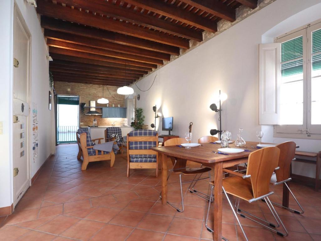 een keuken en eetkamer met een houten tafel en stoelen bij Loft Algavira in Sant Feliu de Guixols