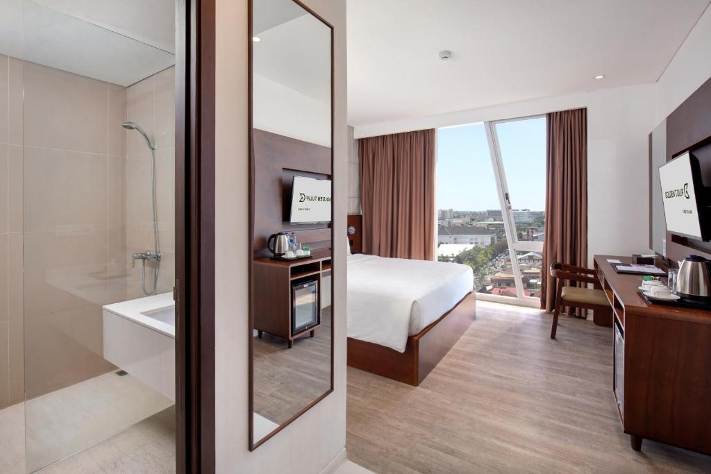 Postel nebo postele na pokoji v ubytování Golden Tulip Pontianak
