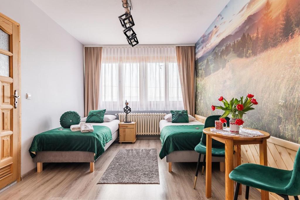 Habitación de hotel con 2 camas y mesa en Pokoje Gościnne U Małgorzaty, en Zakopane
