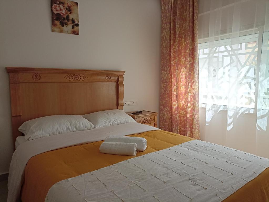 una camera da letto con un letto e un asciugamano sopra di Cozy duplex a Rabat