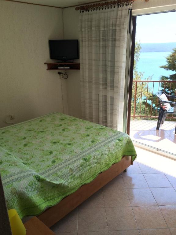 sypialnia z łóżkiem oraz balkon z telewizorem w obiekcie Apartment Bertossin Rovini w mieście Mošćenička Draga