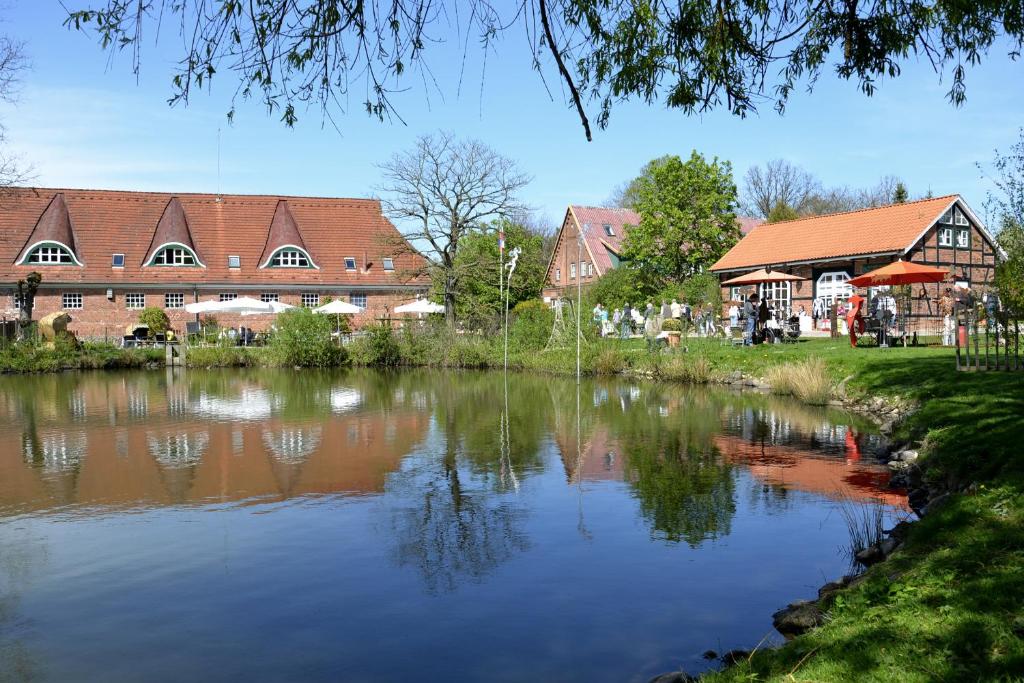 a lake in front of a building with houses at Gut Basthorst in Basthorst