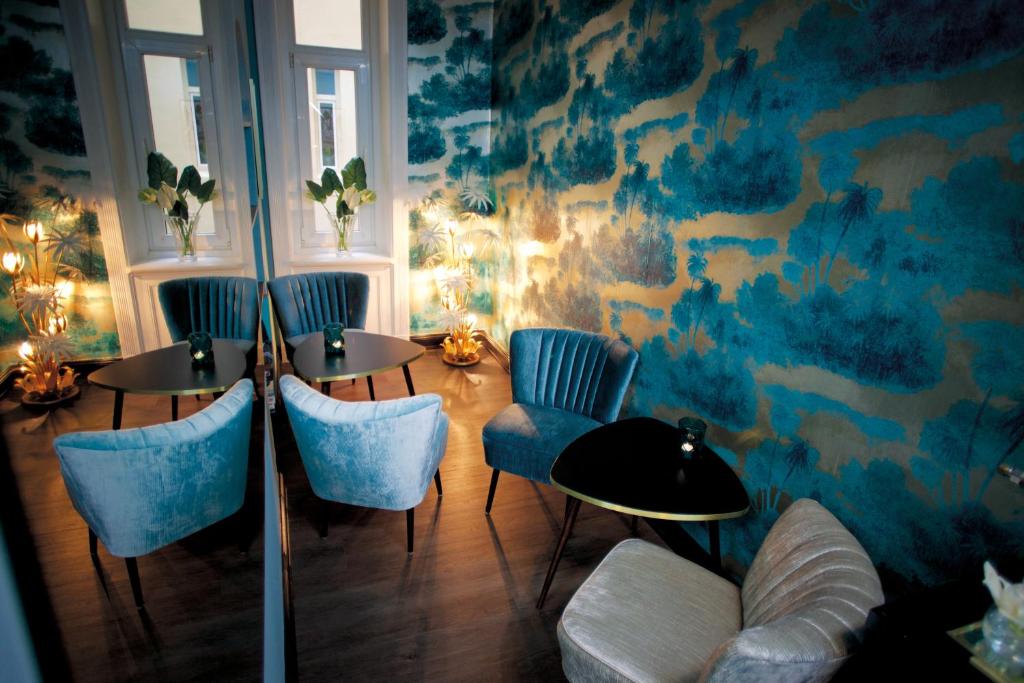 um quarto com duas mesas e cadeiras azuis em Fritz im Pyjama em Hamburgo
