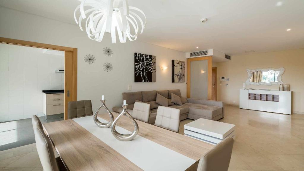 a living room with a couch and a dining table at Marina Vilamoura Aquamar 220 By Vilamoura Sun in Quarteira