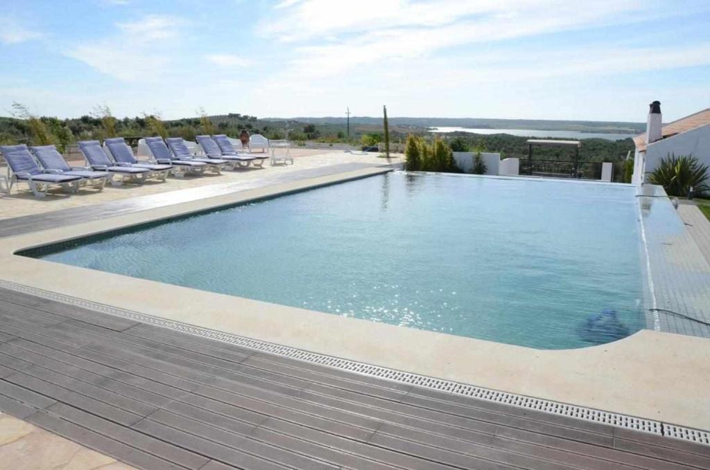 uma grande piscina com espreguiçadeiras e uma piscina em Herdade da Fonte Ferreira em Avis