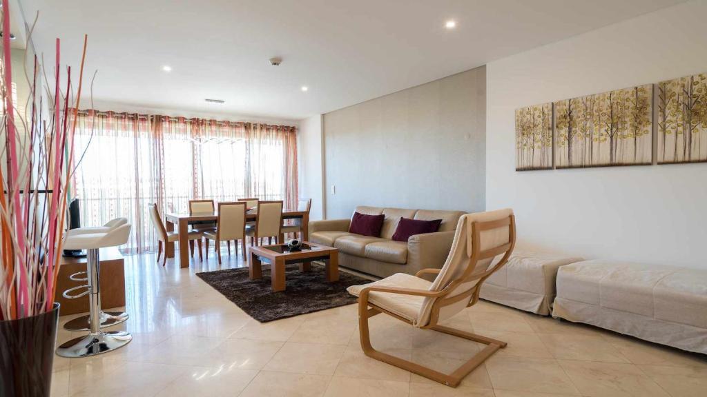 a living room with a couch and a table at Marina Vilamoura Aquamar 203 By Vilamoura Sun in Quarteira