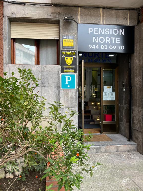 uma entrada para um edifício com uma placa em frente em Pension Norte em Portugalete