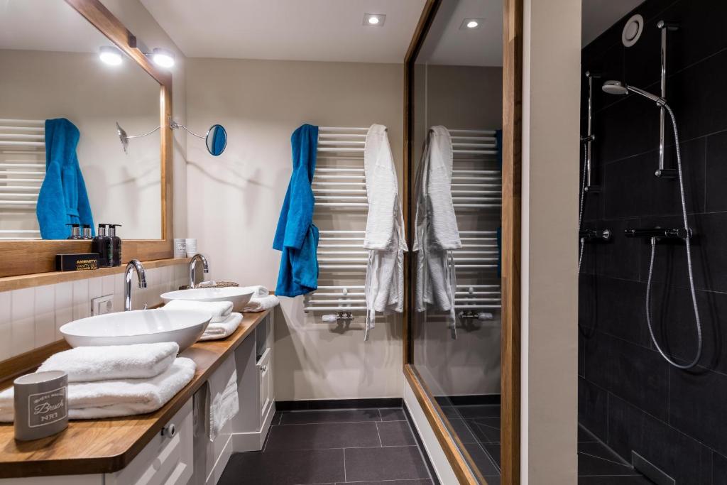 a bathroom with three sinks and a shower at Hotel Zweite Heimat in Sankt Peter-Ording