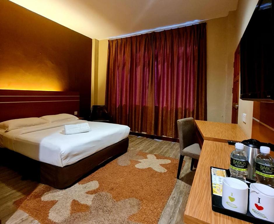 um quarto com uma cama e uma secretária com uma cadeira em Best Star Resort em Pantai Cenang