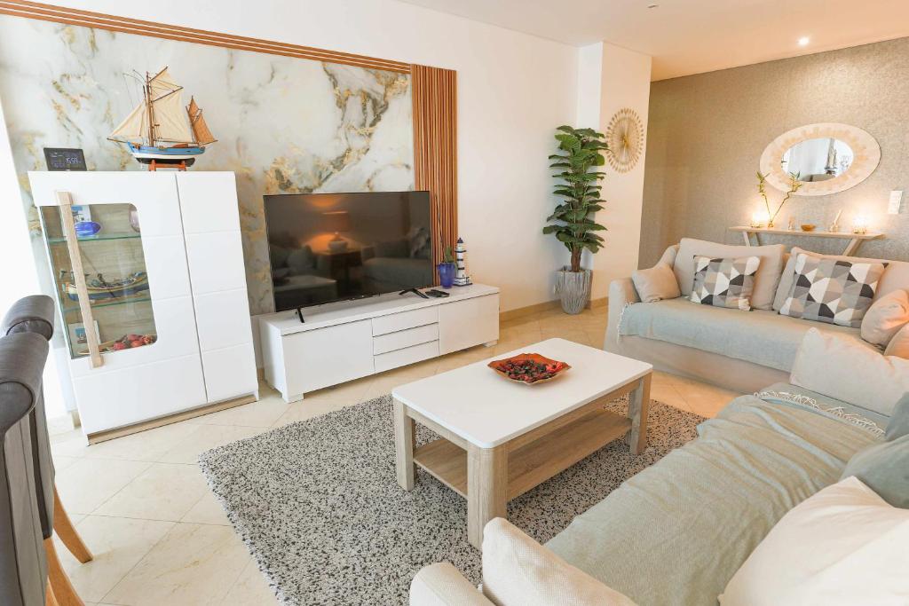 a living room with a couch and a tv at Marina Vilamoura - Aquamar 217 - By Vilamoura Sun in Quarteira