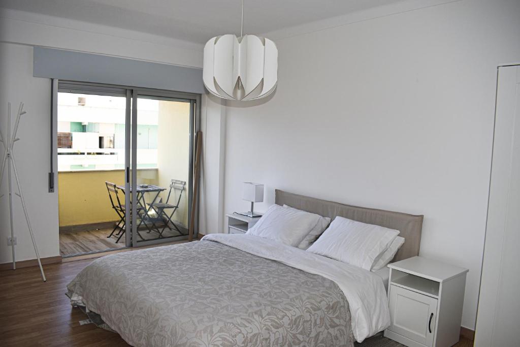 ファロにあるGrowIN Stay Downtownのベッドとシャンデリアのある寝室