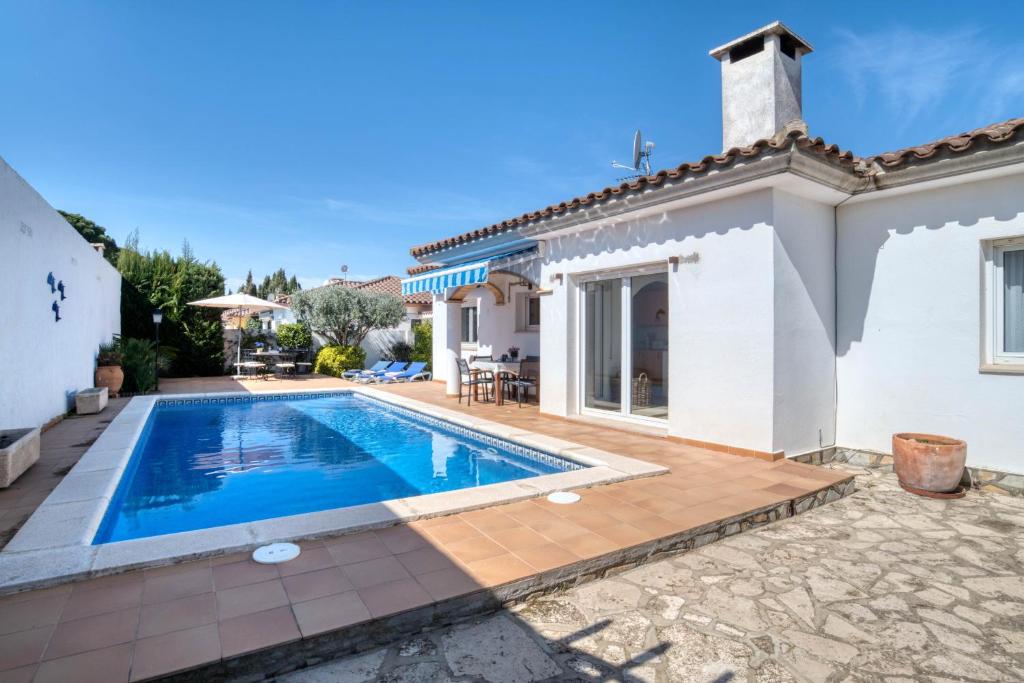 une villa avec une piscine en face d'une maison dans l'établissement La Bellesa, à L'Escala