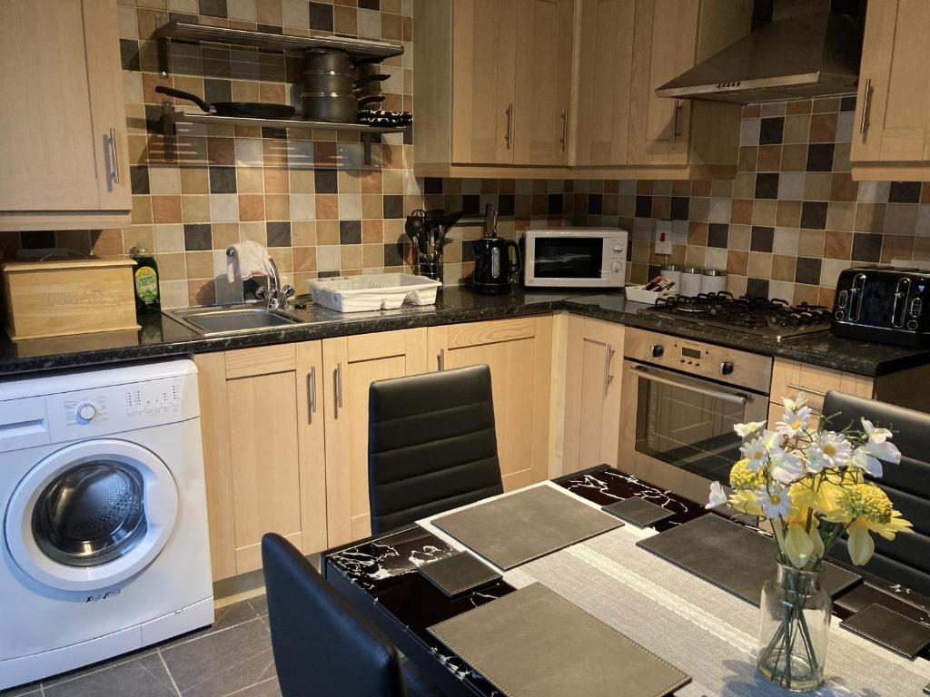 a kitchen with a table and a washing machine at Newbourne Terrace in Derby