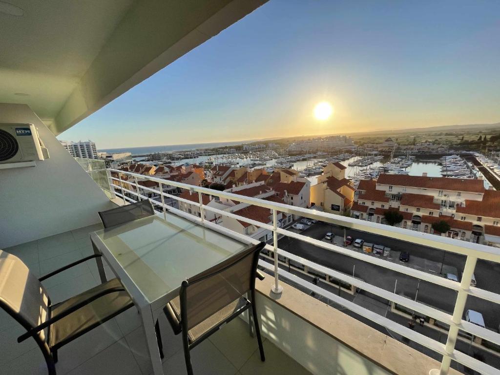 een balkon met een tafel en uitzicht op de stad bij Marina View Apartment By VilamouraSun in Vilamoura