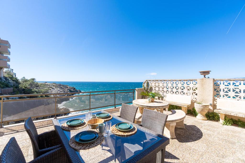 eine Terrasse mit einem Tisch, Stühlen und Meerblick in der Unterkunft Mediterranean Way - El Mirador in Salou