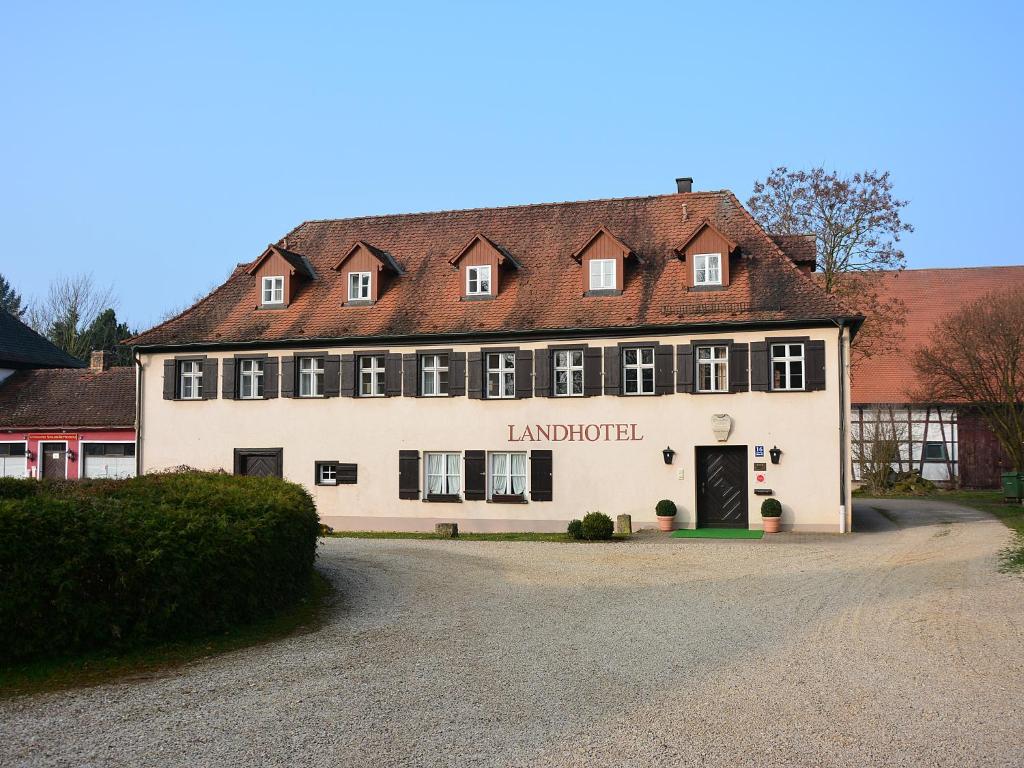ein großes weißes Gebäude mit rotem Dach in der Unterkunft Landhotel Schloss Buttenheim in Buttenheim