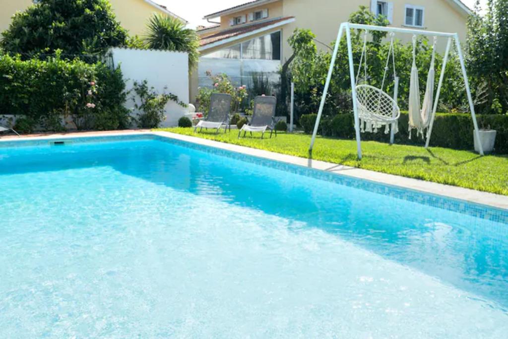 uma piscina com um baloiço e uma casa em Delfim e Carmo - Entire House com Piscina em São Pedro do Sul